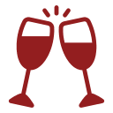 Two red wine glasses are in front of a green background.